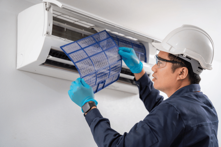 technician cleaning an AC filter
